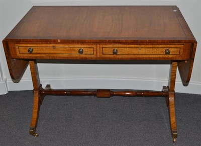Lot 1031 - A Regency Style Satinwood and Rosewood Crossbanded Sofa Table, with two oak lined frieze...