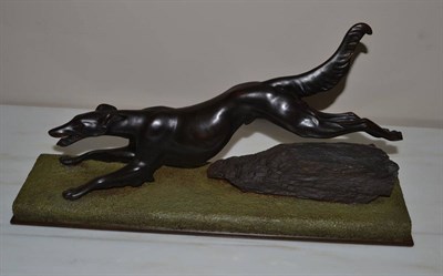 Lot 1098 - A Pair of Bronze Cast Figures of Greyhounds, 20th century, each running above a rocky green...