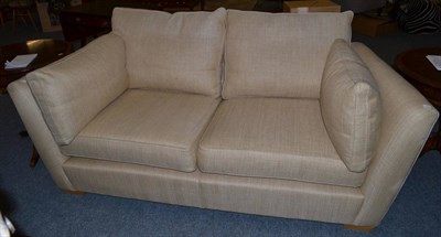 Lot 1130 - A Duresta Two-Seater Sofa, upholstered in light brown fabric with six squab cushions and...