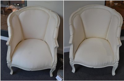 Lot 1137 - A Pair of 19th Century Bergeres, repainted white and upholstered  in cream cotton, the moulded...