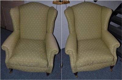 Lot 1139 - A Pair of Wingback Chairs, labelled Wade Upholstery, upholstered in green and fleur de lys...