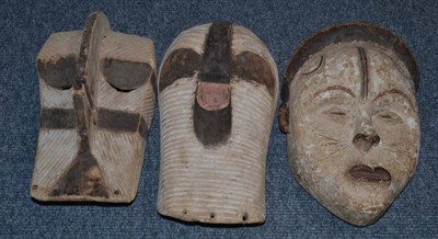 Lot 1190 - A Punu Mask, with white painted oval face and pursed heart shaped mouth; Two Songye Kifwebe...