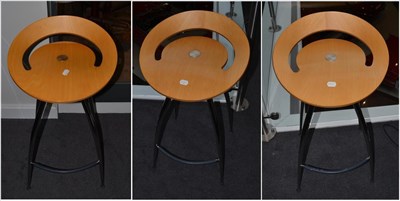 Lot 1206 - A Set of Three Lyra Macis Beech and Stainless Steel Bar Stools, the seats of circular curved...