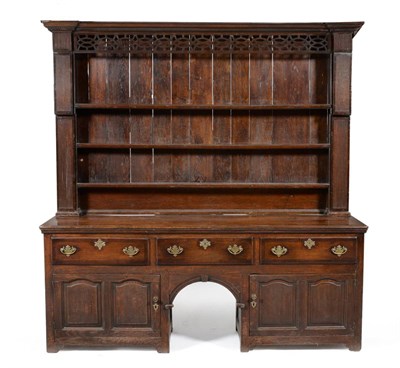 Lot 967 - An 18th Century English Joined Oak Enclosed Dresser and Rack, with dentil cornice above a fret...