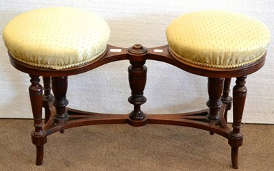 Lot 977 - A Late Victorian Walnut Revolving Duet Stool, covered in cream silk fabric, raised on turned...