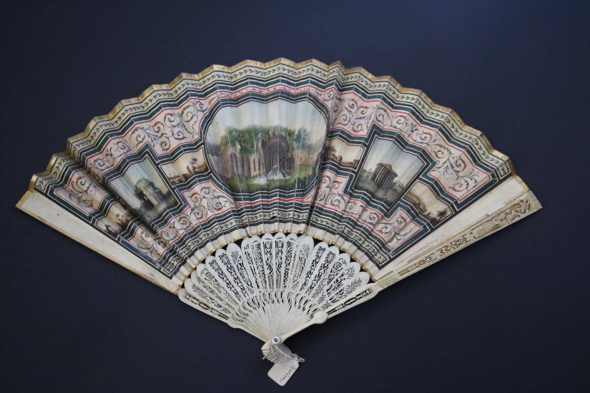 Lot 372 - A Regency Topographical Fan, the double paper leaf mounted on slender pierced and carved ivory...
