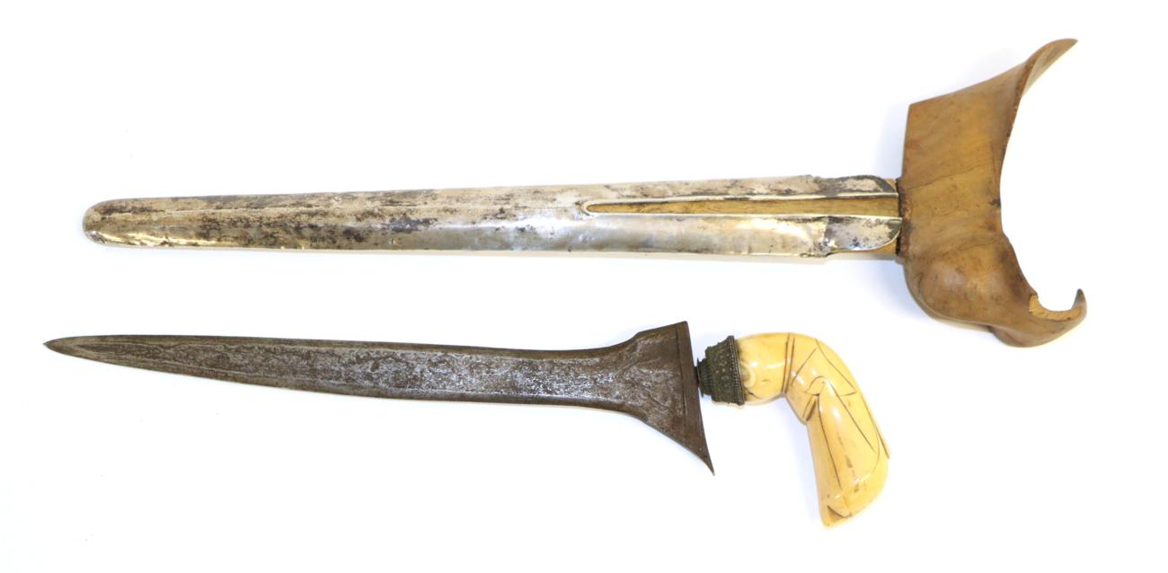 Lot 101 - A 19th Century Indonesian Kris, Celebes, the 31cm straight pamor blade with silver filigree mendak