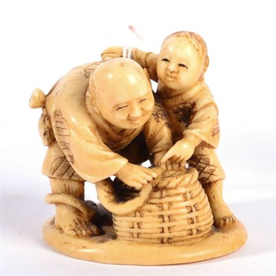 Lot 104 - A Japanese Ivory Okimono, Meiji period, as a man and boy with a snake in a basket, 6.5cm high
