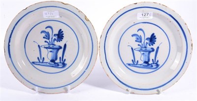Lot 127 - A Pair of English Delft Plates, circa 1700, painted in blue with urns of flowers within line...