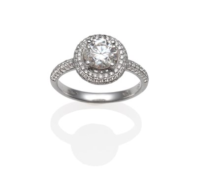 Lot 186 - A Diamond Cluster Ring, the round brilliant cut diamond in a white four claw setting, over a...