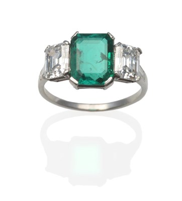 Lot 218 - An Emerald and Diamond Three Stone Ring, the emerald-cut emerald between two emerald-cut...