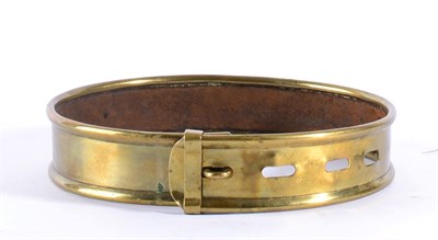 Lot 318 - A Brass Dog Collar, mid 19th century, with rolled edges and leather insert, maximum diameter 17.5cm