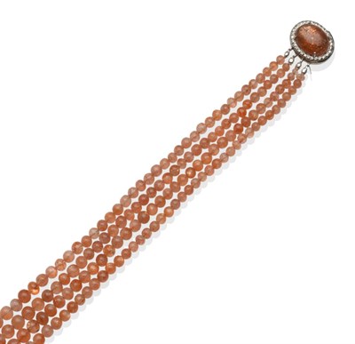 Lot 260 - A Sunstone Necklace, four rows of graduated sunstone beads to an oval clasp with a cabochon...