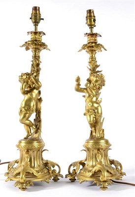 Lot 389 - A Pair of Brass Figural Candlesticks, after Clodion, with cherubs playing musical instruments...