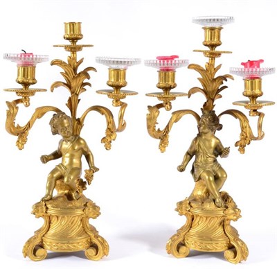 Lot 412 - A Pair of French Gilt Bronze Figural Three-Light Candelabra, late 19th century, with leaf...