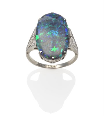 Lot 276 - An Art Deco Black Opal and Diamond Ring, the polished oval black opal in white claws, to...