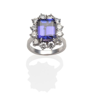 Lot 319 - An 18 Carat White Gold Tanzanite and Diamond Cluster Ring, the emerald-cut tanzanite within a...