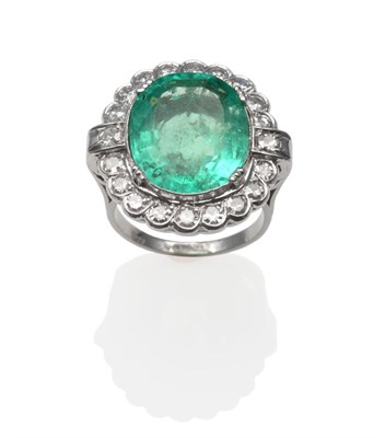 Lot 323 - An Emerald and Diamond Cluster Ring, the oval mixed cut emerald within a border of eight-cut...