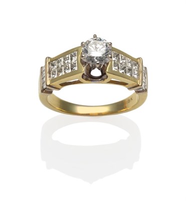 Lot 338 - A Diamond Ring, a round brilliant cut diamond in a yellow claw setting above shoulders tension...