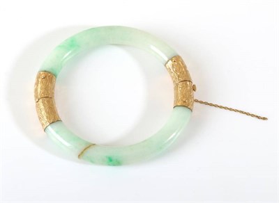 Lot 663 - A Jade Bangle, with chased mounts, measures 6.5mm inner diameter