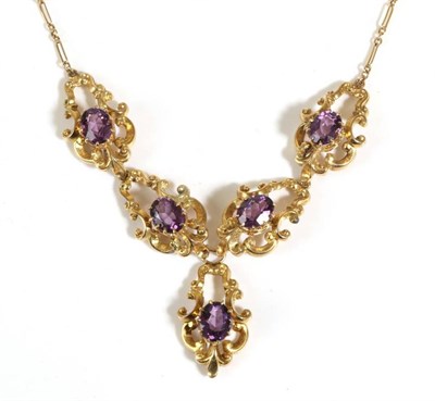 Lot 673 - An Amethyst Necklace, the front with oval cut amethysts in claw settings within fancy c-scroll...