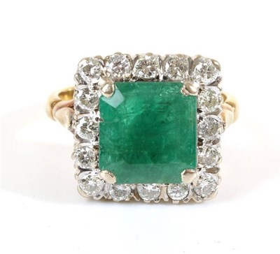 Lot 689 - An Emerald and Diamond Cluster Ring, a square octagonal cut emerald in a claw setting, within a...