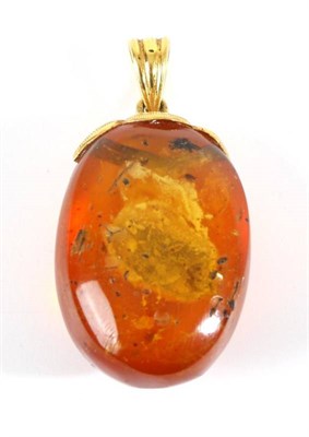 Lot 703 - An Amber Pendant, an amber drop, with various organic inclusions, to a fancy chased mount, measures