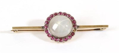 Lot 709 - A Star Sapphire and Ruby Cluster Brooch, a round cabochon grey star sapphire within a border of...