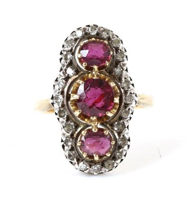 Lot 714 - A Ruby and Diamond Navette Ring, three graduated round cut rubies within a frame of eight-cut...