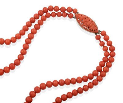 Lot 738 - A Double Strand Red Coral Bead Necklace, graduated coral beads knotted to a foliate carved and...