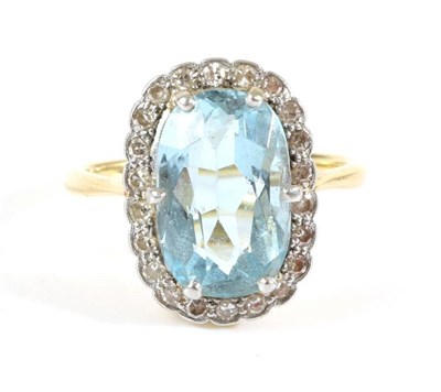 Lot 742 - An Aquamarine and Diamond Cluster Ring, an oval cut aquamarine in a claw setting, within a...