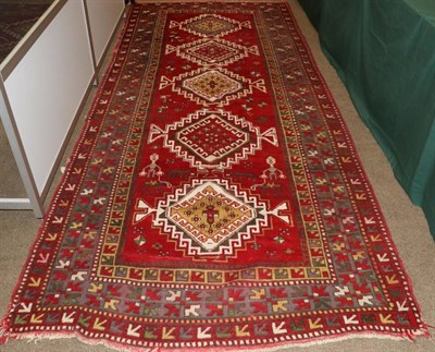 Lot 1317 - Kazak Long Rug Central Caucasus, circa 1920 The blood red field with zoomorphic and anthropomorphic