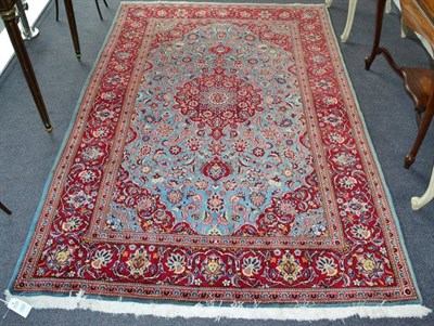 Lot 1320 - Kashan Rug Central Iran, circa 1960 The ice blue field of scrolling vines around a raspberry...