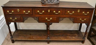 Lot 1340 - A George III Oak Open Dresser, mid 18th century, with an arrangement of six drawers above a...
