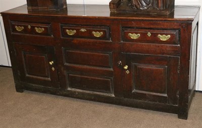 Lot 1342 - An Early 18th Century Oak Enclosed Dresser, with three frieze drawers above two fielded panels...