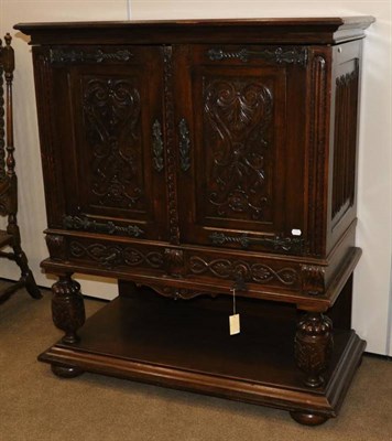 Lot 1343 - A 1920/30s Carved Oak Cupboard, with parquetry decorated top and linen fold side panels, the...