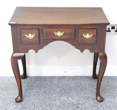 Lot 1351 - A George III Oak Dressing Table, 18th century in part, with three small drawers above an arched...