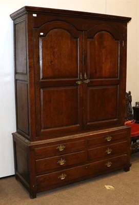 Lot 1365 - A Mid 18th Century Joined Oak Press Cupboard, the bold cornice above arched and fielded panel doors