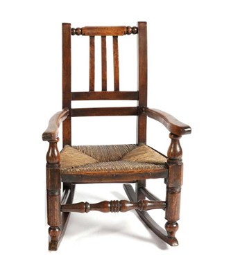 Lot 1369 - A 19th Century Lancashire Ash and Rush Seated Child's Rocking Chair, with spindle turned front...