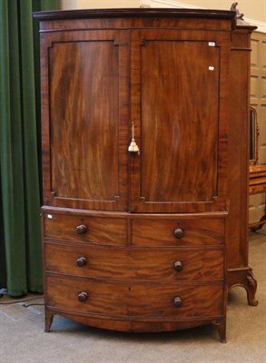Lot 1405 - A Late George III Mahogany Bowfront Linen Press, early 19th century, the moulded cupboard doors...