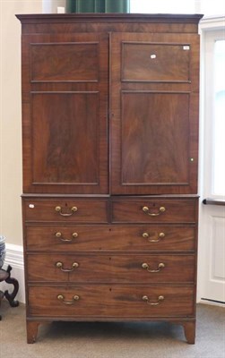 Lot 1423 - A Mahogany Linen Press, circa 1820, with moulded panel doors enclosing hanging space (trays...