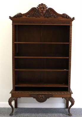 Lot 1434 - A Late Victorian Walnut Bookcase, the arched pediment centred by a grotesque mask, with four...