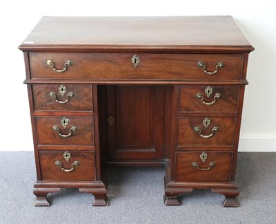 Lot 1437 - A Late George III Mahogany Kneehole Dressing Table, early 19th century, the moulded top above a...
