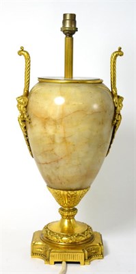 Lot 1026 - A Gilt Metal Mounted Onyx Lamp Base, in Regency style, of ovoid form with loop and mask handles...