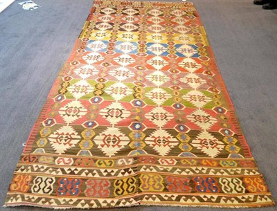 Lot 245 - Anatolian Kilim The field of polychrome bands containing stepped medallions enclosed by borders...