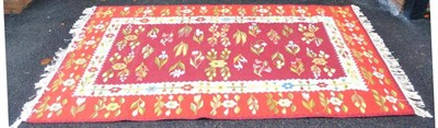 Lot 252 - Pualkaus Kilim The maroon field with columns of flowering plants enclosed by tomato red...