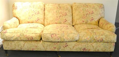 Lot 379 - George Smith LtdL A Victorian Style Three-Seater Sofa, circa 1999, covered in beige and floral...