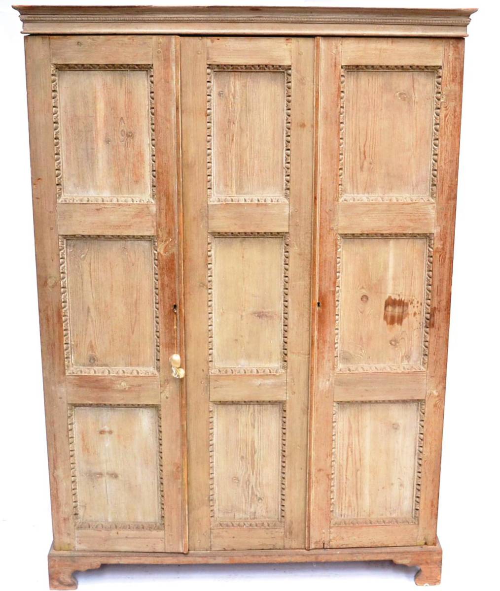 Lot 322 - A 19th Century Limed Oak Triple Door Cupboard, with egg and dart carved moulding and nine...
