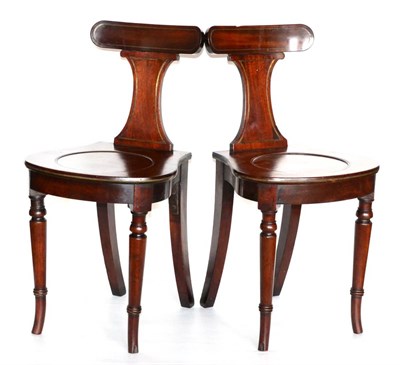 Lot 1114 - A Pair of George III Mahogany Hall Chairs, early 19th century, the curved top rails and back...