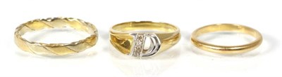 Lot 186 - A diamond set 'D' initial ring, finger size L1/2, stamped '18K'; a two colour twisted band...